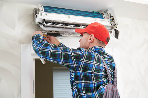 A worker installs a climatization system indoors in Greenwich, Connecticut.