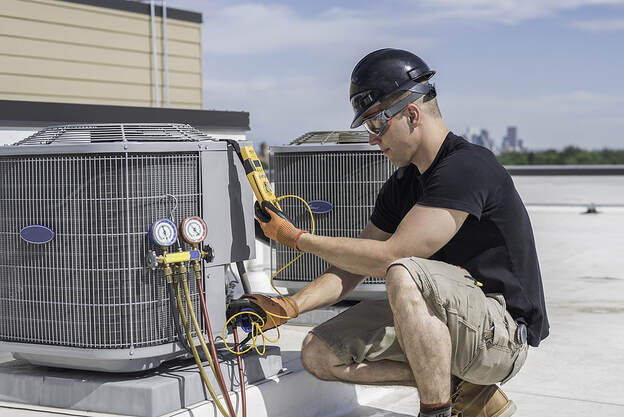 A technician inspects an air conditioner in Greenwich, CT.