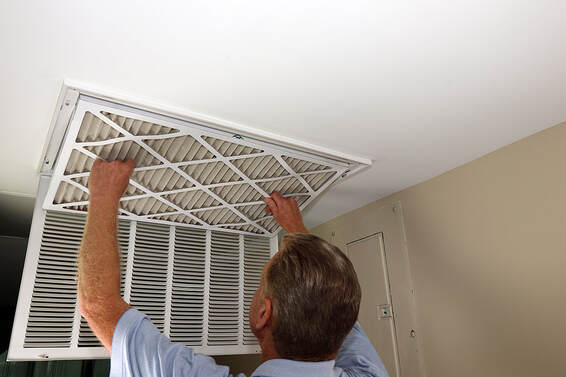 In Greenwich, CT, a person cleans an air filter on a high-efficiency furnace.