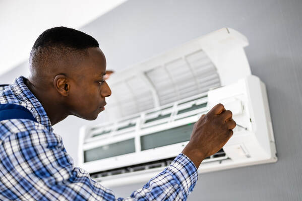 In Greenwich, CT, an AC electrician repairs an air conditioner.
