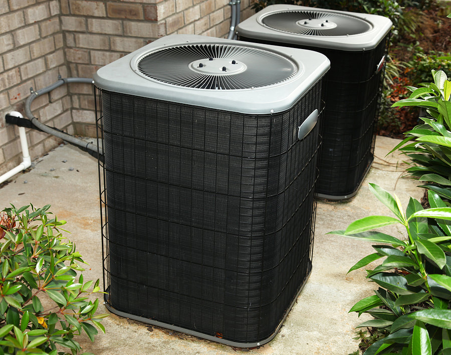 A central air conditioning unit is installed on a cement slab in a Greenwich, CT, home.